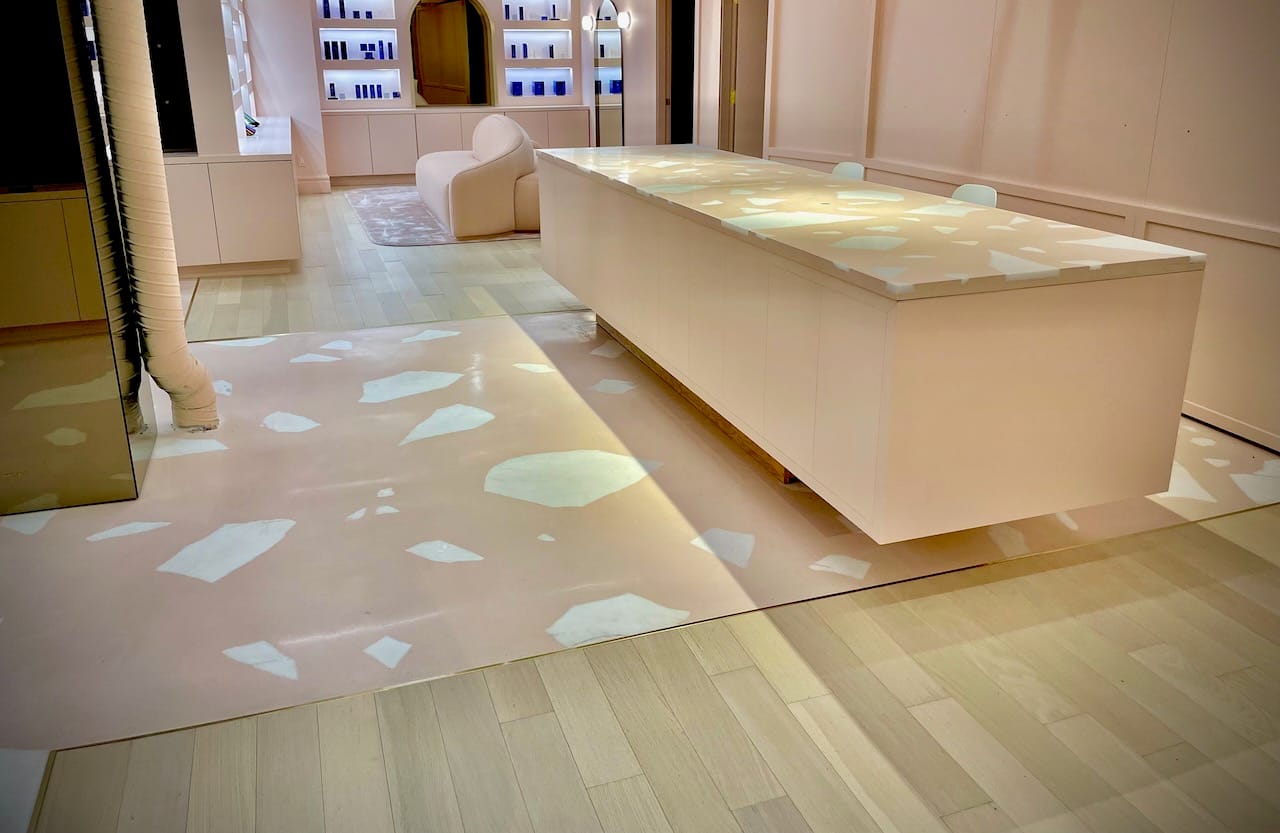 Retail interior with pale terrazzo floor and display island.